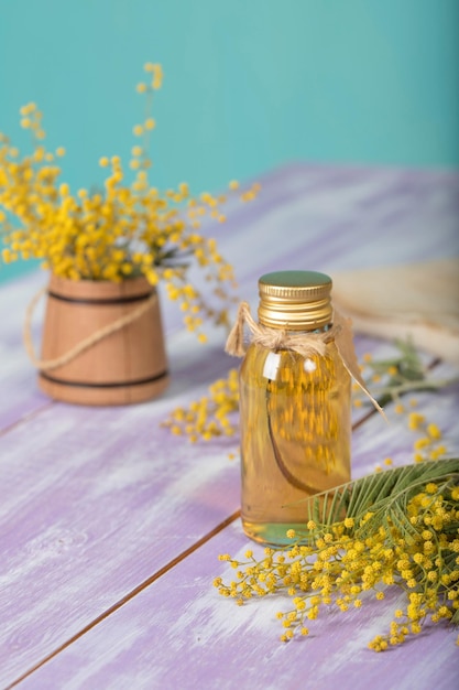 Mimosa flowers extract on a wooden surface. Closeup