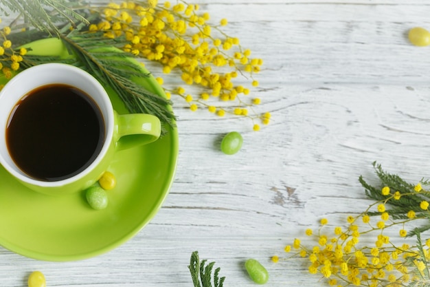 Mimosa, lemon and coffee on light wooden table