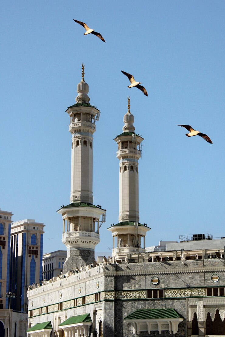 Photo the minarets of the meccan kaaba with flying seagulls mecca saudi arabia