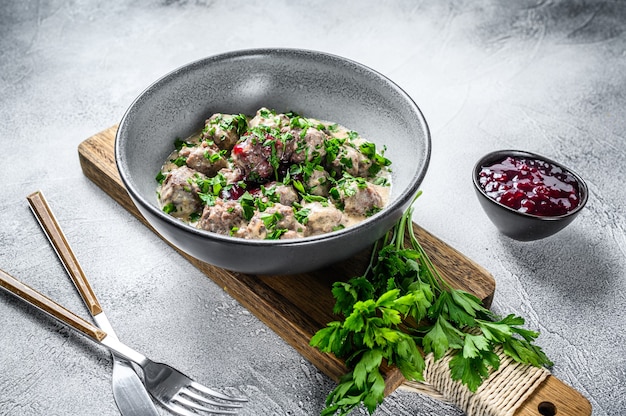Mince meat meatballs with cream sauce on a plate.