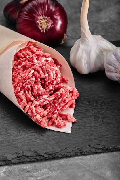 Minced Meat Beef as detailed close-up shot on dark wooden background.