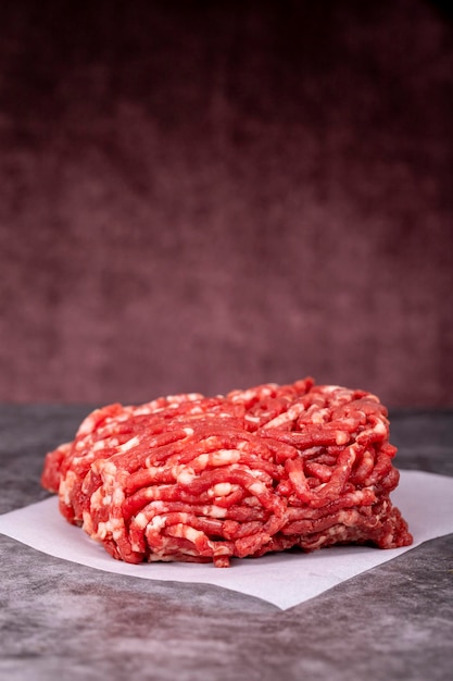 Minced meat on butcher paper Fresh ground beef on wood background