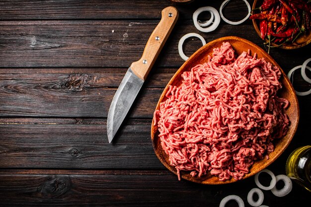 Foto carne macinata su un piatto con anelli di cipolla