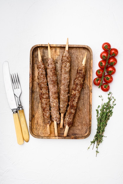 Minced and shaped lamb mutton kebabs set, on white stone table background, top view flat lay