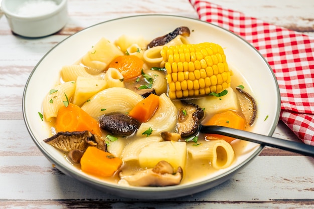 Minced view of an exquisite homemade chicken, vegetable and mushroom soup with noodles and corn. Natural and healthy food concept