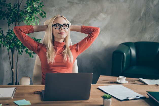 Minded secretary beautiful woman finish start-up work boss project look stretch hands think when weekends rest relax sit table wear red turtleneck in office workstation