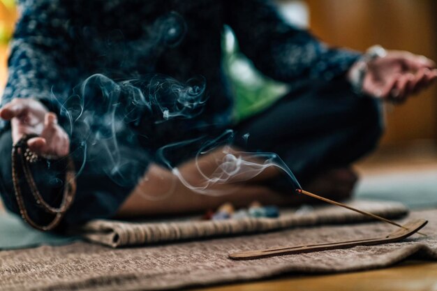 Mindful Woman Meditating with Burning Incense Sticks Sitting in Lotus Pose Hands