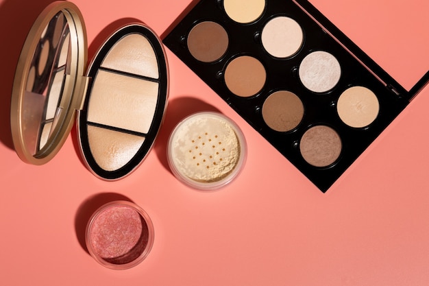 Mineral powder, pressed blush and kit for face contouring on a pink background. Closeup shot