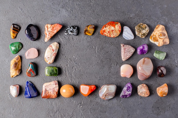 Минеральные камни на черном бетонном фоне. Концепция использования минералов в астрологии и альтернативной или дополнительной медицине.