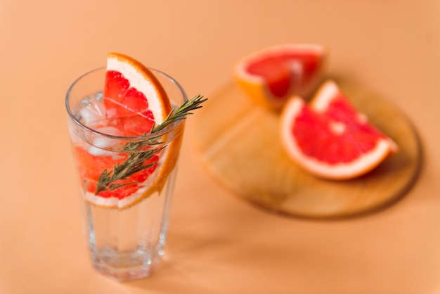 Acqua minerale in bicchiere con pompelmo e rosmarino