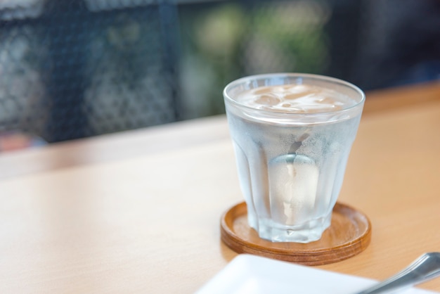 Mineral water in glass on wood table with abstract background