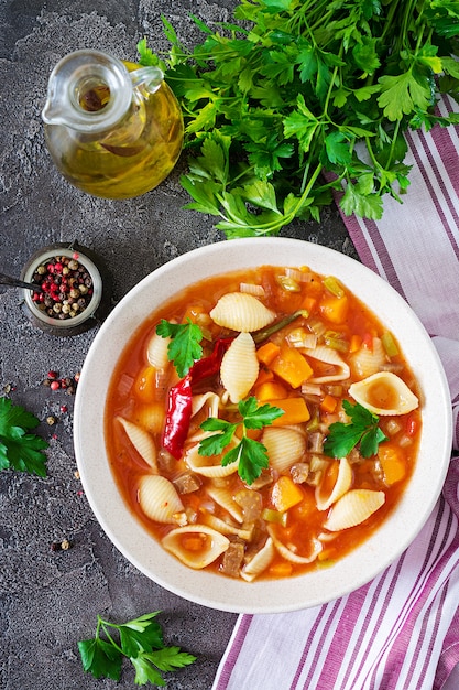 Minestrone, Italiaanse groentesoep met pasta op tafel. Veganistisch eten. Bovenaanzicht