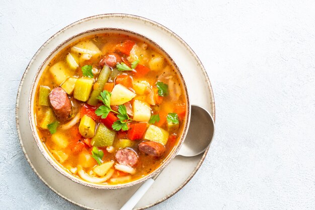 Minestrone soup italian vegetable soup with smoked sausages top view