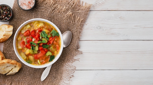 Minestrone soup in white dish on white wooden table