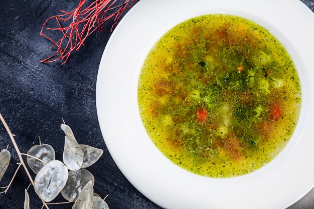 Minestrone top view served in white bowl on dark surface