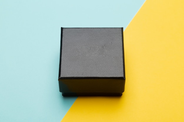 Mini black box product packaging isolated on yellow half blue