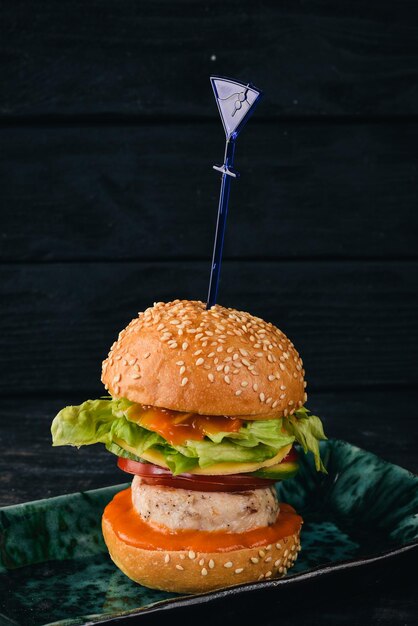 Foto mini hamburger con filetto di pollo vista dall'alto su sfondo di legno nero copia spazio