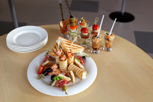 Mini Canape with meat and vegetables in glass cups stand on the buffet On the plate canape of prawn