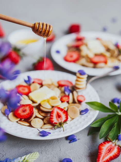 Mini cereal pancakes with honey and strawberries