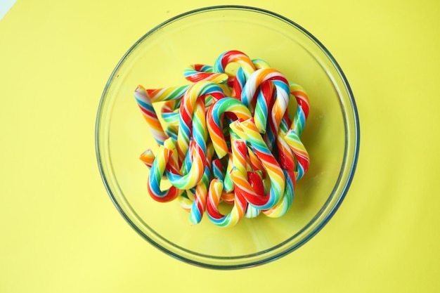 Mini cherry candy canes on yellow background