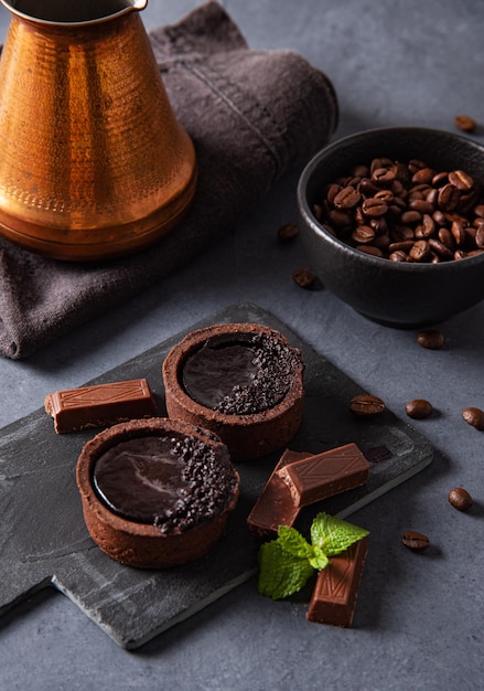Mini chocoladetaartjes met koffiebonen op een donkere achtergrond. Afbeelding close-up