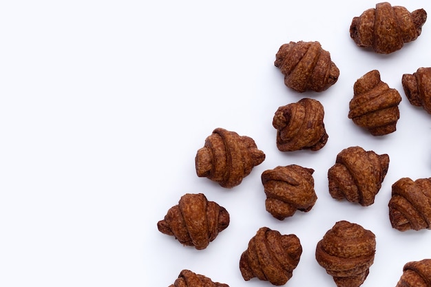 Mini croissant al cioccolato su sfondo bianco.