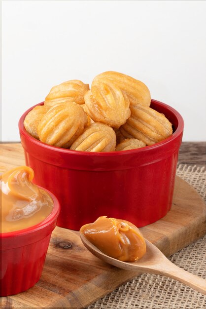 Mini churros in a red bowl stuffed with dulce de leche.