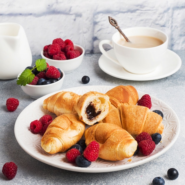 Photo mini croissants with chocolate and berries