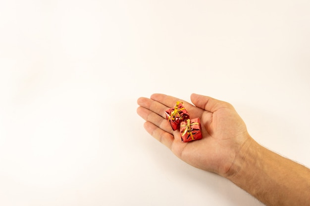 Mini gifts in hand on white background