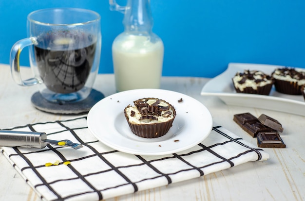 Mini homemade cheesecakes in chocolate baskets and coffee with milk