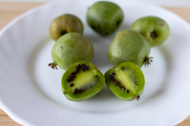 Mini kiwi actinidia op een houten bord Een uitgesneden klein fruit Selectieve focus