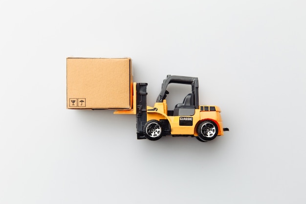 Mini model of forklift with carton box isolated on white