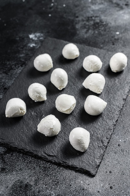 Mini mozzarella cheese balls on a stone board