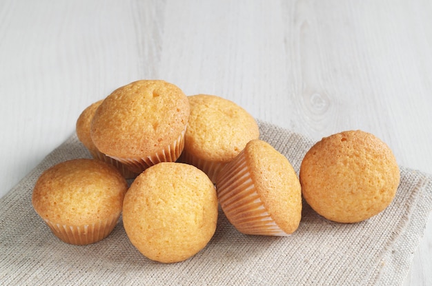 Mini muffins for breakfast on fabric is located on a light wooden background with copy space