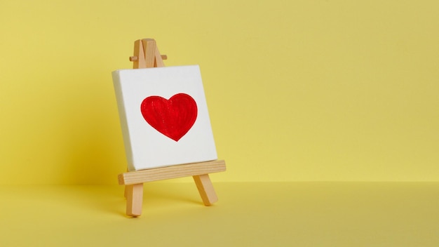 Mini painting on an easel. Drawn red heart.