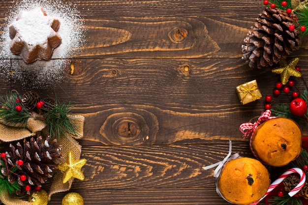 Mini panettone with fruits and Christmas decoration on wooden background