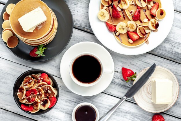 Mini pannenkoeken met aardbeien en bananen op een plaat op tafel