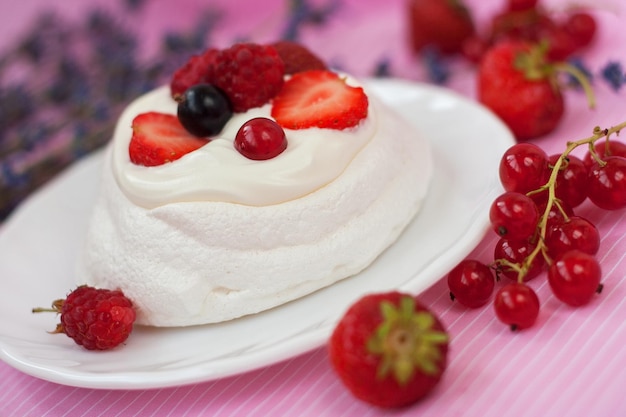 Mini Pavlova Cake dessert with fresh strawberries black and red currants Summer dessert with berries