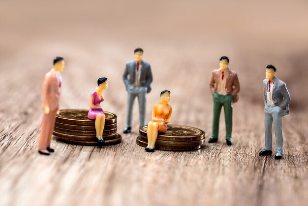 Mini people with coins on the table