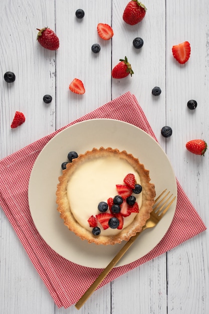 Mini pie strawberry blueberry cream white wood table