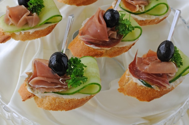 Mini sandwiches met ham en komkommer op stokbrood