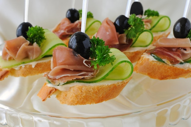 Mini sandwiches with ham and cucumber on a baguette