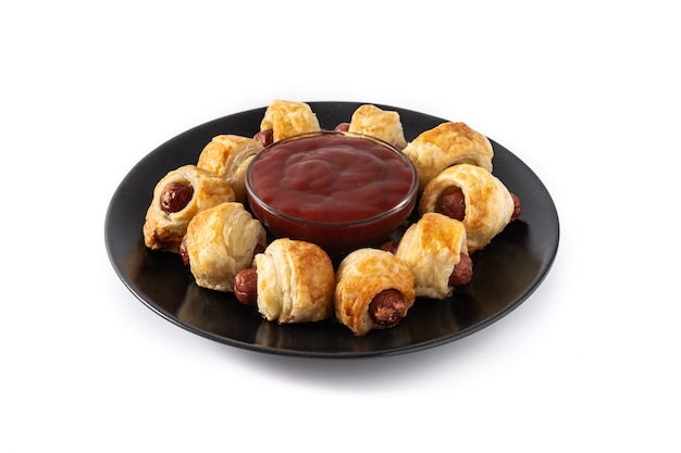 Mini sausages wrapped in puff pastry isolated on white