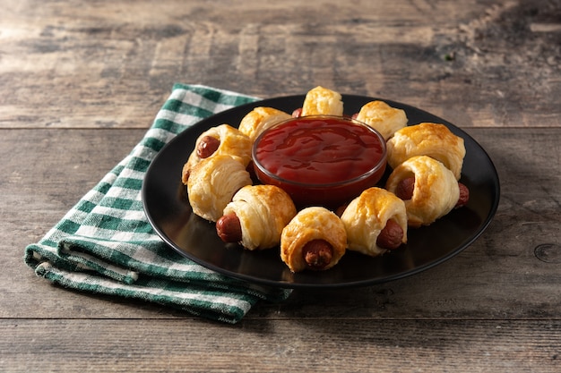 Mini sausages wrapped in puff pastry with ketchup sauce