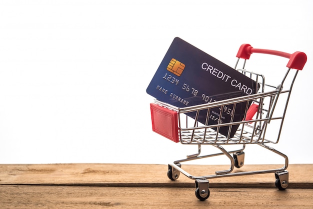 Mini shopping cart on table for work and credit card for work to shopping online concept 