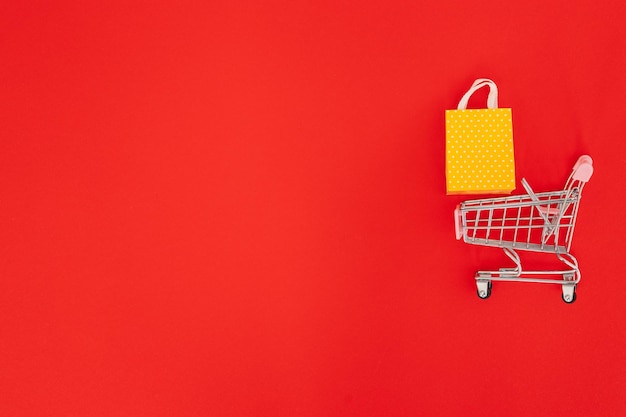 Mini shopping trolley on red background