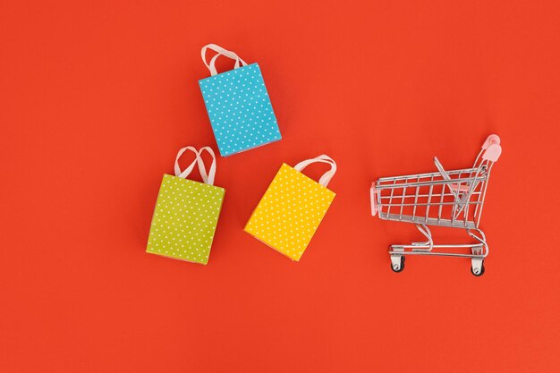 Mini shopping trolley on red background