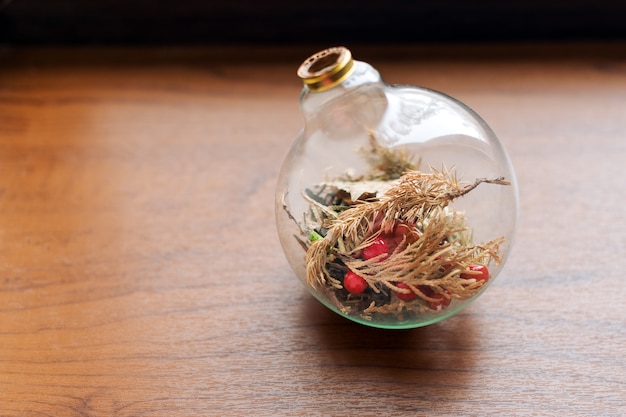 Mini succulente tuin in glazen terrarium op houten vensterbank, vetplanten met zand en rotsen in glazen doos, huisdecoratie-elementen.