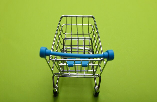 Photo mini supermarket trolley on green. shopping concept