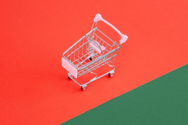 Mini supermarket trolley on red green background